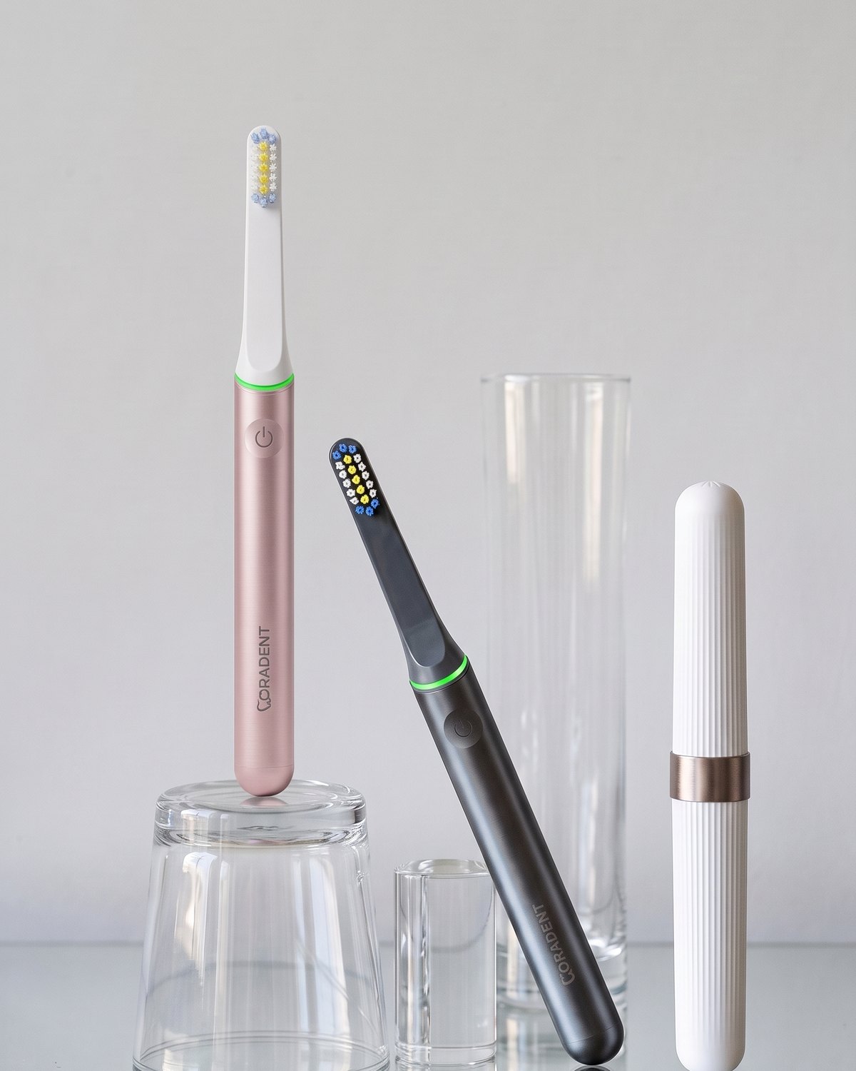 Two PulseONE sonic toothbrushes, Rose and Graphite, with a travel case