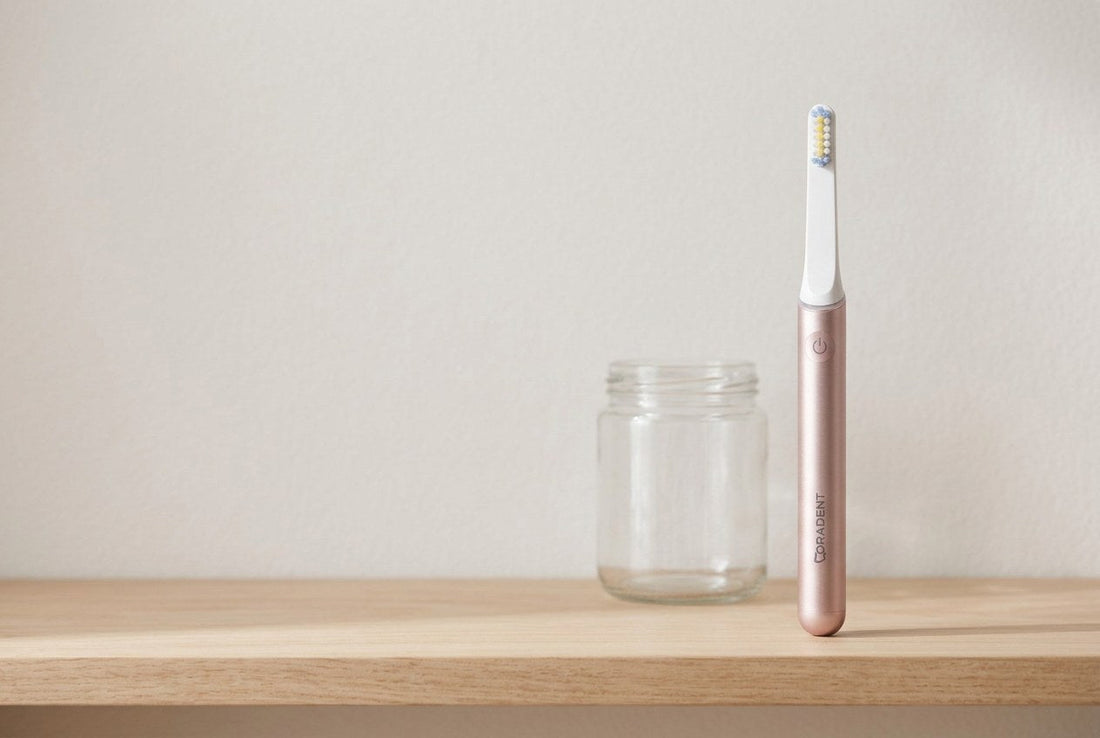 PulseONE sonic toothbrush in Rose standing on a pale timber shelf next to a glass jar