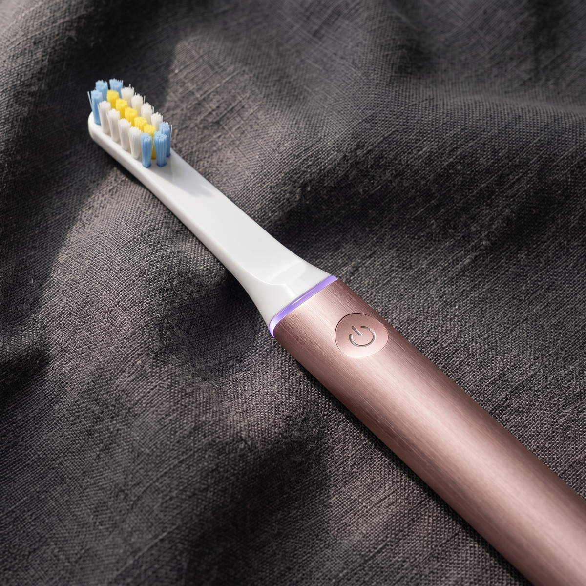 PulseONE sonic toothbrush in Rose, brushed aluminium body and power button