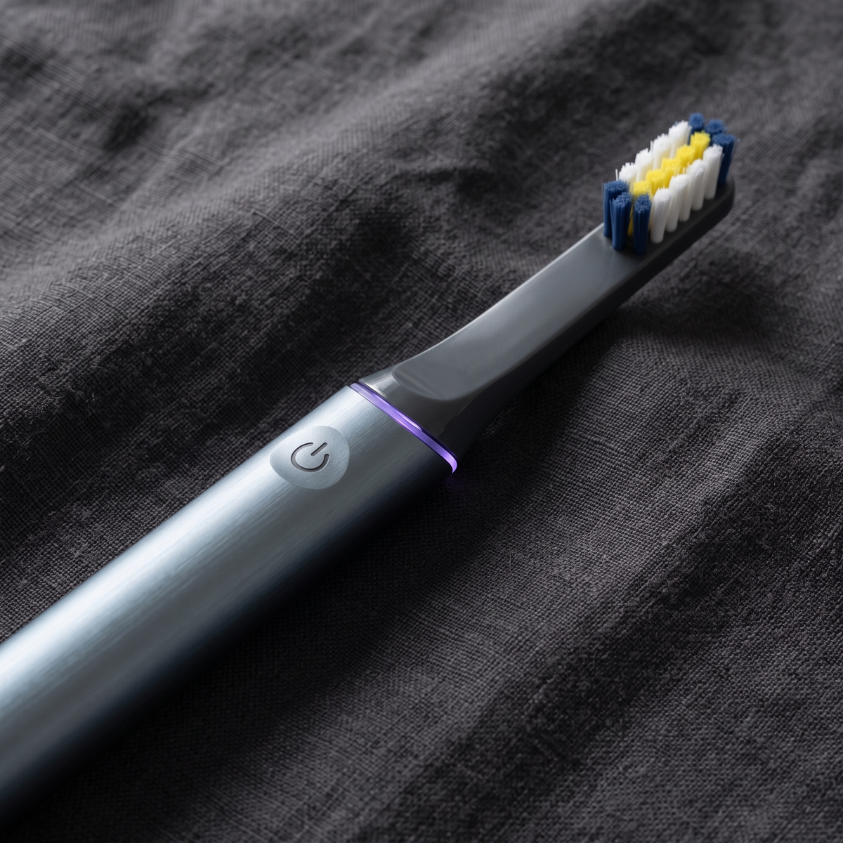 PulseONE sonic toothbrush in Graphite, brushed aluminium body and power button