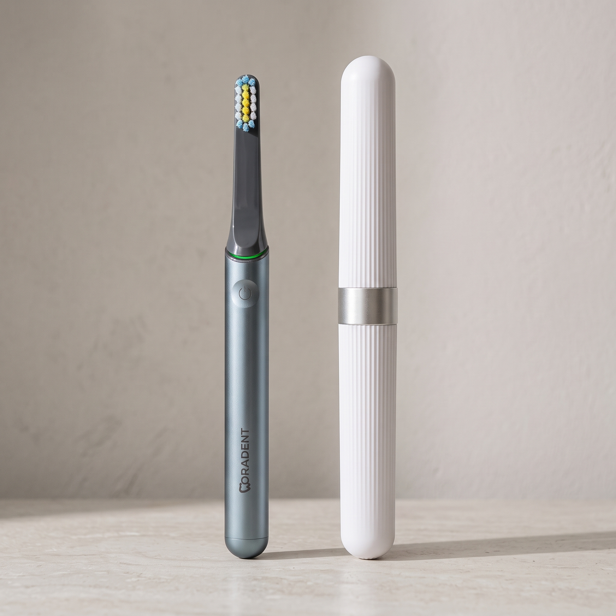 PulseONE sonic toothbrush in Graphite, beside its travel case